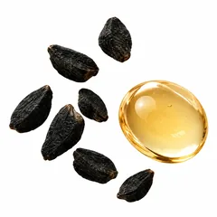 Black cumin seeds beside a drop of golden Nigella oil.